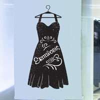 Αυτοκόλλητο βιτρίνας από βινύλιο που απεικονίζει ένα μαύρο φόρεμα σε κρεμάστρα. Το φόρεμα έχει άσπρα σημάδια και σχέδια ενώ στη μέση έχει τη λέξη 